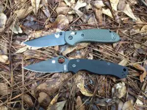 spyderco and benchmade knives on the ground