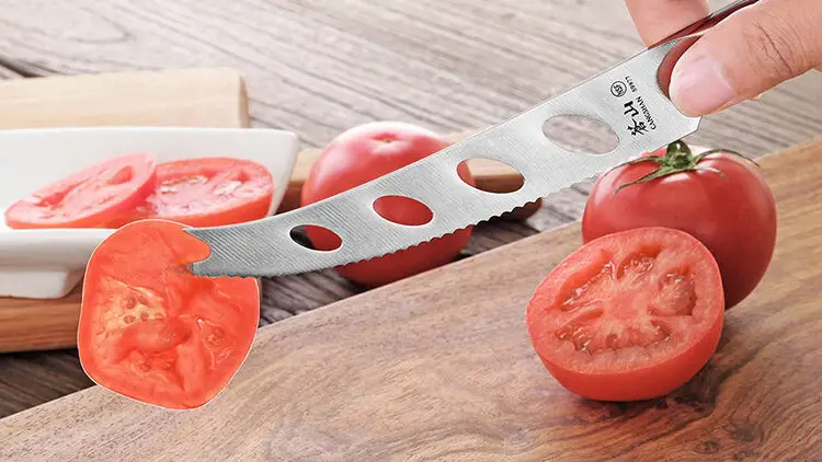 two points of a knife with tomato
